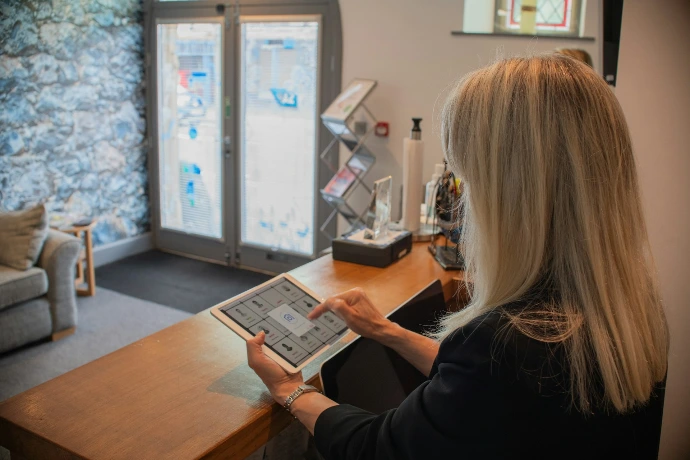Woman using a tablet at a reception desk.